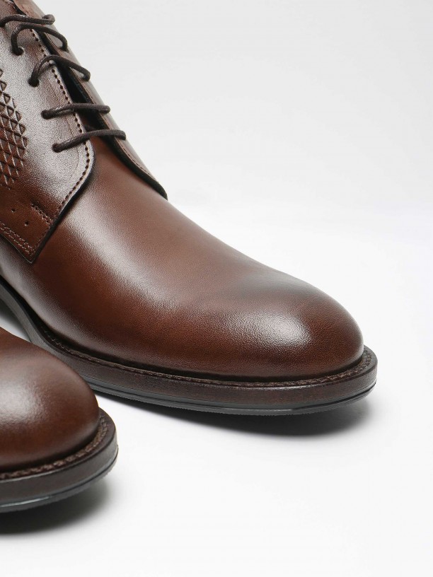 Polished leather boots with embossed pattern
